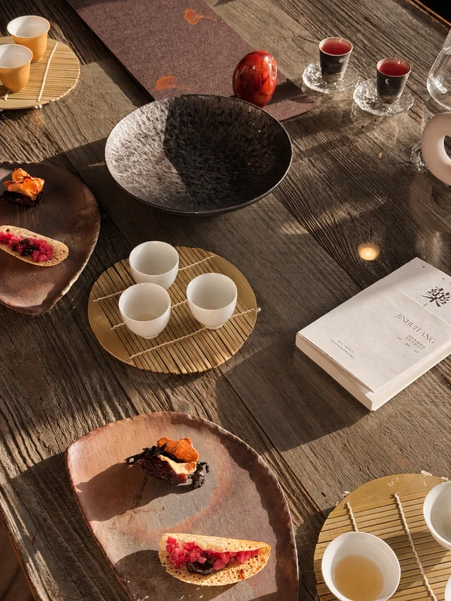 A table set with tea, ceramics and small plates in afternoon light.